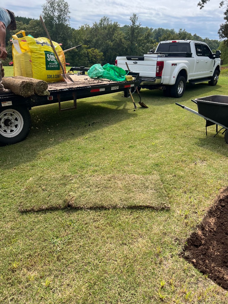 Truck and trailer delivering sod and soil materials for lawn installation