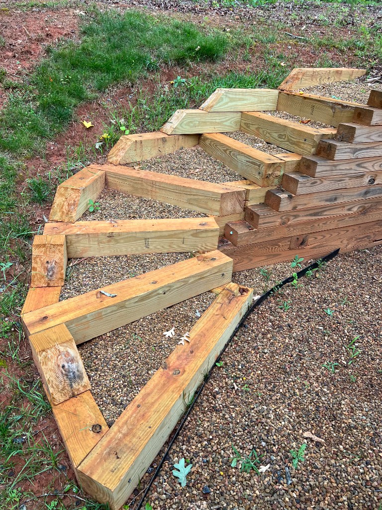Timber staircase with gravel fill sections on a sloped yard